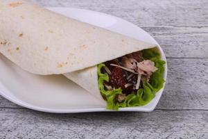 Tortilla with tuna, salad and dried tomato photo