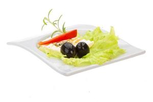 Soft cheese on salad with olives photo