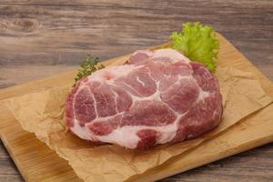 Raw pork steak over wooden board photo