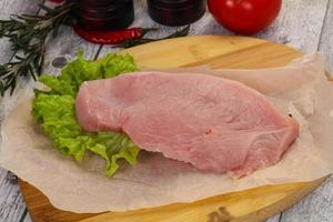 Raw Turkey steak served rosemary photo