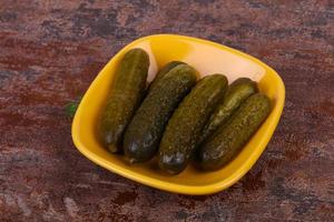 Pickled cucumbers heap in the bowl photo