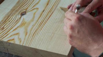 carpintero marca la pieza de trabajo con la ayuda de un inglete y un lápiz video