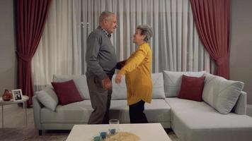 knuffel met liefde. een oude vrouw die van haar man houdt. de oude vrouw kijkt haar man glimlachend aan. slow-motion. video