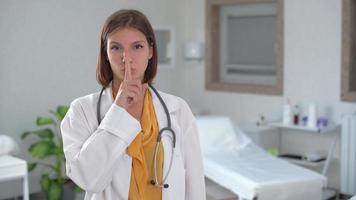 Doctor shut up. Female doctor looking up at camera and laughing while taking notes video