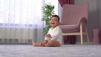 lächelndes und krabbelndes Baby. Das Baby lacht und krabbelt dann. Seine süßen Zähne in seinem Mund ziehen die Aufmerksamkeit auf sich. Dies ist ein Zeitlupenvideo.