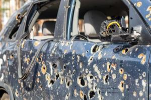 Car riddled with bullets. War of Russia against Ukraine. A car of civilians shot by the Russian military during the evacuation of women and children. Ukraine, Irpen - May 12, 2022. photo