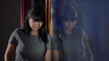 Young beautiful girl crying. Crying looking out the window. Sad worried young woman, attractive face, trying to deal with psychological problems. Sad angry lonely lady thinks distressed grief. video