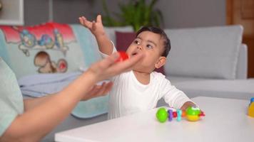 bambino felice che gioca con sua madre. il sorriso e i denti del bambino felice che gioca con sua madre attirano l'attenzione. questo è un video al rallentatore.