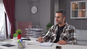 Online meeting from home. Man working from home attending online meeting, speaking and working by taking notes. video