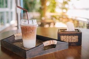 café capuchino helado en vaso de plástico con paja listo para beber en la cafetería foto