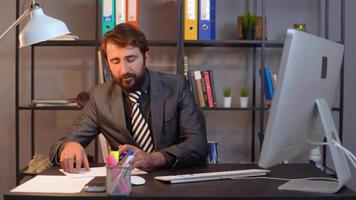 affärsman tar anteckningar på papper. han skriver ner saker från datorn till den bärbara datorn. video