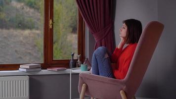 soledad. mujer abrumada por la soledad en casa. triste mujer abrumada. perfil de mujer atrapada frente a la ventana en casa. mirando por la ventana. video