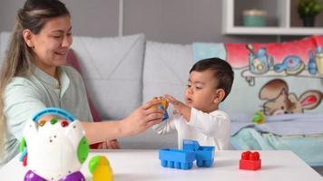 madre bambino vita quotidiana. la madre gioca con il suo bambino con i lego e trascorre piacevoli momenti con il suo bambino. video