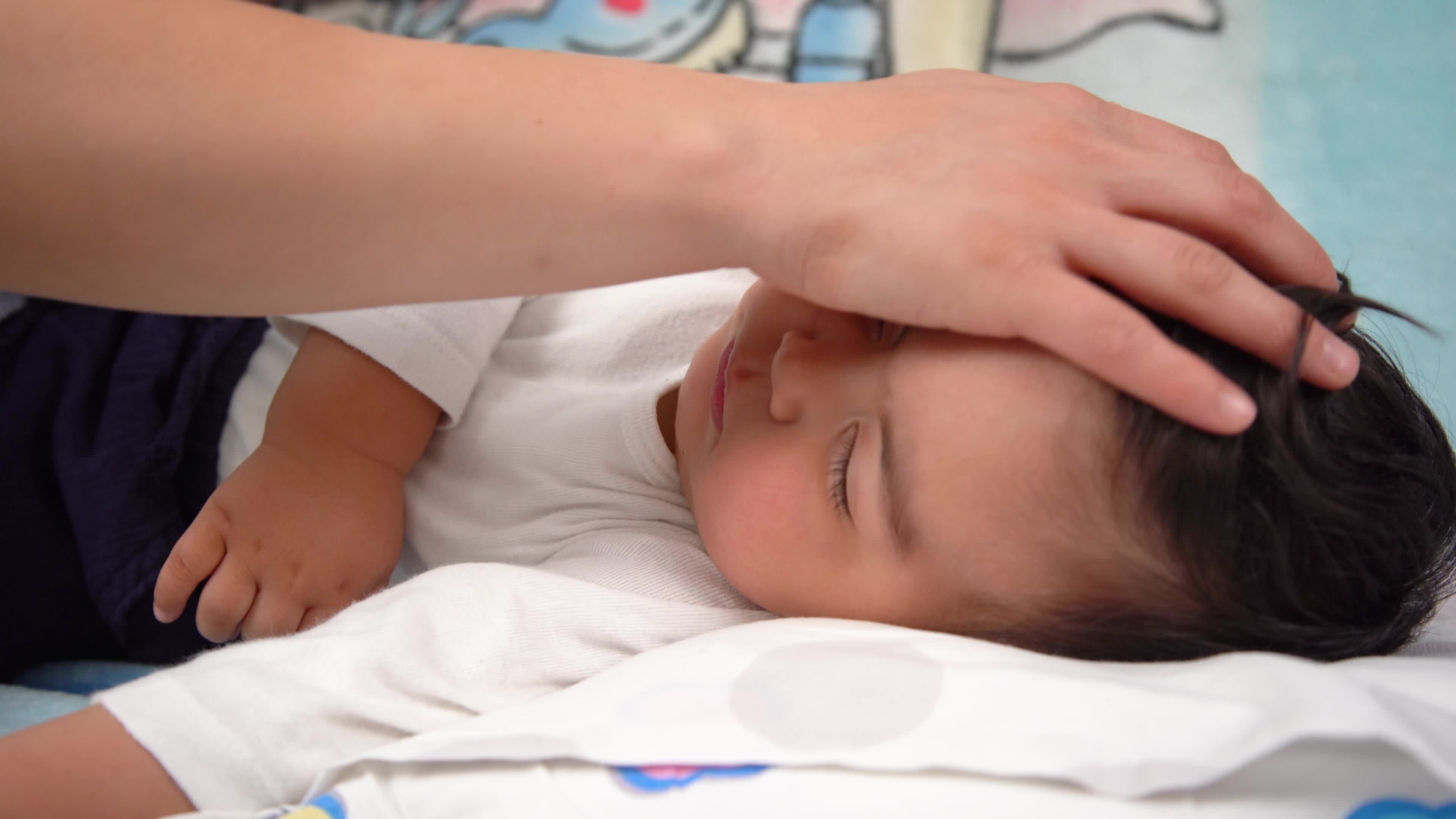 Mother covering baby's blanket. The mother covers her sleeping baby's
