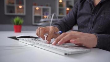 éxito en la computadora de casa. el teclado y las manos son visibles en el primer plano. la persona está feliz con lo que sucede en la computadora, su rostro no es visible. video