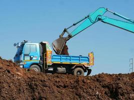 Excavadora cargadora de ruedas y basculante volquete. foto