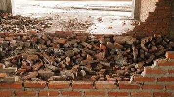 primer plano de los escombros de un edificio industrial que se derrumba en un montón de hormigón y ladrillo. y los escombros irregulares causados por la falla de los ingenieros en la construcción abandonada. foto