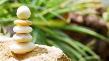 The Balance Stones are stacked as pyramids in a soft natural bokeh background, representing the calm philosophical concept of Jainism's wellness. photo