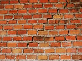 An old brick wall that cracks due to a non-standard construction. photo