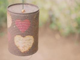 una lata con una forma de corazón colgando detrás es un bokeh. foto