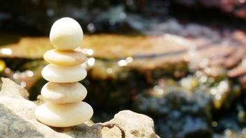 las piedras de equilibrio se apilan como pirámides en un suave fondo bokeh natural, lo que representa el tranquilo concepto filosófico del bienestar del jainismo. foto