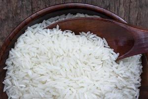 white rice Jasmine rice served in a wooden bowl, isolated over wooden background