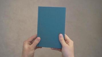 två händer som öppnar en bok med tomma sidor video