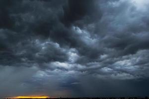 The dark sky had clouds gathered to the left and a strong storm before it rained. photo