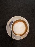 Coffee in white and stanless spoon on black fabric background.copy space. photo