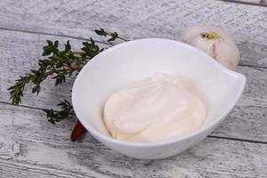 Mayonnaise sauce in the white bowl served thyme and garlic photo