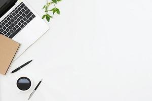 Flat lay photo of office desk with laptop, notebook, pen, coffee with copy space background