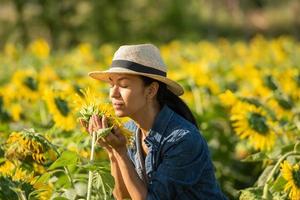 Beautiful young woman in a field of sunflowers in a white dress. travel on the weekend concept. portrait of authentic woman in straw hat . Outdoors on the sunflower field. photo