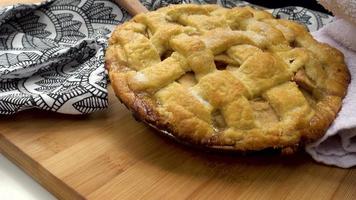Freshly baked apple pie put down on table. video