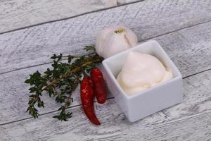 Mayonnaise sauce in the white bowl served thyme and garlic photo