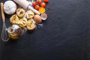 Mixed dried pasta selection on black stone background photo