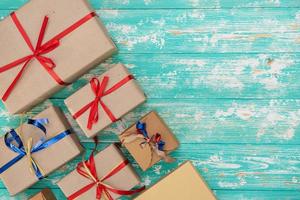 christmas holiday gift shopping background. view from above with copy space. craft paper present boxes tied from rope on blue background, top view. flat lay composition for birthday. photo