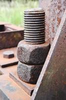 Old rusty bolts and nuts on the base of the tower frame. photo