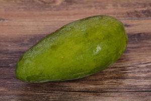 Green tasty mango over wooden background photo