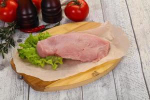 Raw Turkey steak served rosemary photo