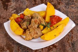 Baked pork meat with potao and tomato photo