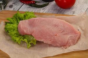 Raw Turkey steak served rosemary photo