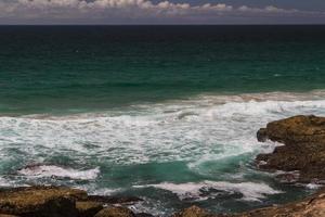 The waves fighting about deserted rocky coast of Atlantic ocean, Portugal photo