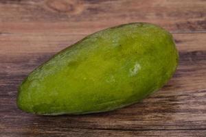 Green tasty mango over wooden background photo