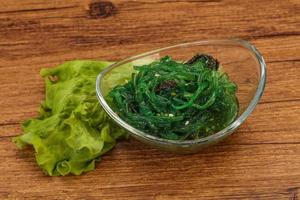 Green Chuka Seaweed Salad Isolated on White Background Top View. Wakame Sea Kelp Salat photo