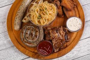 Meat plate with grilled sausages, ribs and chicken wings photo