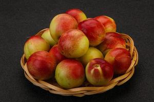 Sweet small nectarines in the basket photo