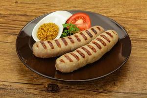 Grilled natural pork sausages with sauce photo