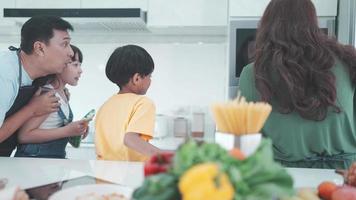 família asiática com filhos gosta e feliz em cozinhar na cozinha em casa, estilo de vida de felicidade de pessoas que são pais para cozinhar juntos, sorrir e alegria comendo comida no jantar ou na hora da manhã video