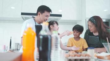 la familia asiática con niños disfruta y feliz de cocinar en la cocina en casa, el estilo de vida feliz de las personas que crían para cocinar juntos, sonríen y se alegran de comer en la cena o en la mañana