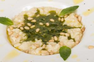 photo of delicious risotto dish with herbs and cedar nut on white background